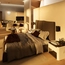 Modernes Schlafzimmer mit großem Bett, Sofa, Fernseher und Badezimmer